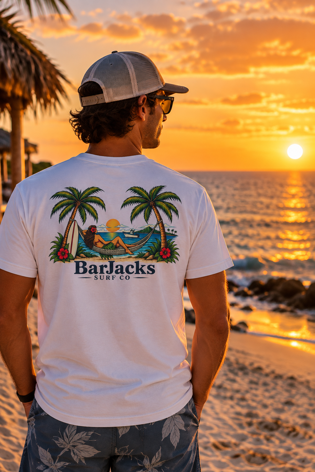 Man on the beach at sunset wearing the Bar Jacks Surf Co Hula Girl Hammock T-Shirt, back view