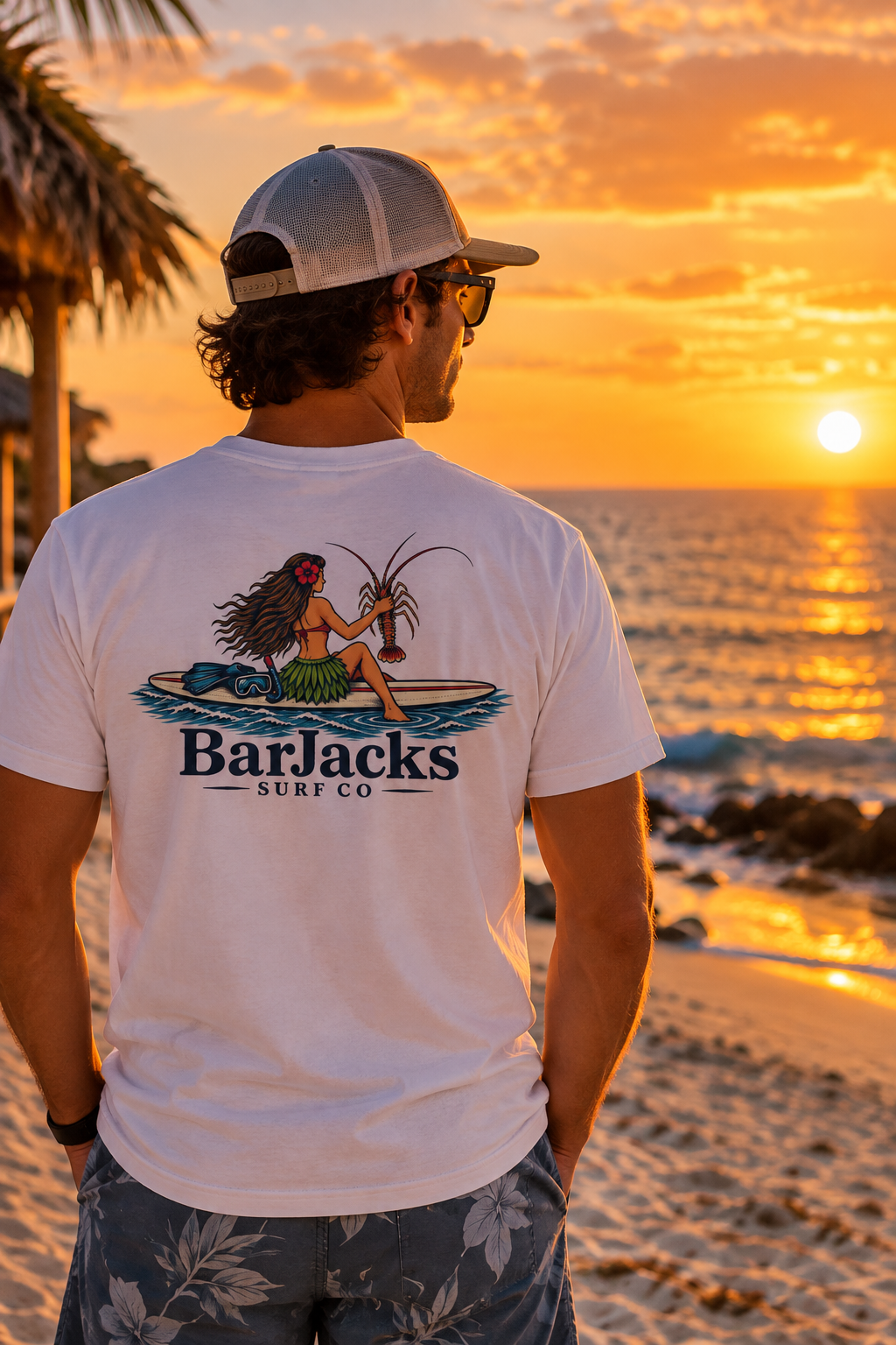 Man on the beach at sunset wearing the Bar Jacks Surf Co Hula Girl Lobster T-Shirt, back view